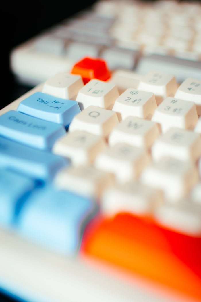 Vibrant close-up of a multicolored computer keyboard emphasizing blue, red, and white keys.